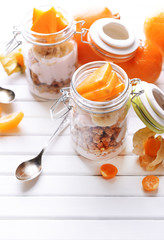 Healthy layered dessert with muesli and fruits on table