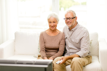 happy senior couple watching tv at home