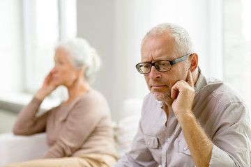 senior couple sitting on sofa at home
