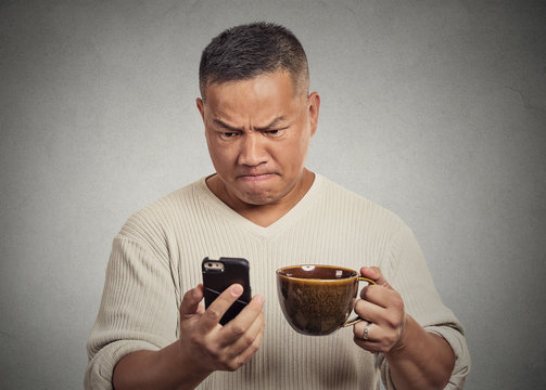 worried angry frustrated man reading bad news sms on smartphone