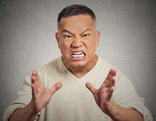 Angry man screaming isolated on grey wall background 