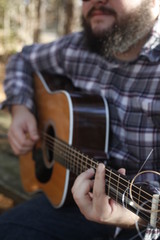 A folk country musician playing his guitar.