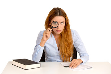 woman with glasses skeptically looking through magnifying glass