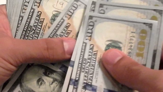Close-up of a businessman's hands counting hundred dollar bills