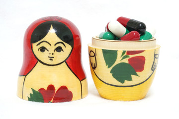 Russian Babushka nesting dolls among drug capsules