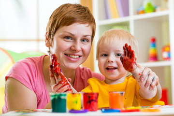mother and kid paint together at home