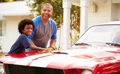 Grandfather And Grandson Cleaning Restored Classic Car