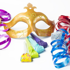 Carnival mask with colorful streamers and party horns on white b