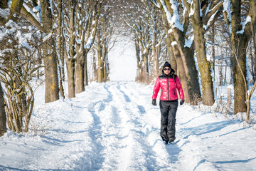 Fototapeta na wymiar Woman hiking in winter through the snow