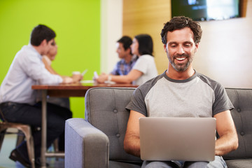 Man Sitting On Sofa And Working In Design Studio