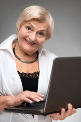 Elderly woman holding the laptop