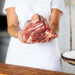 Midsection Of Butcher Holding Meat Piece