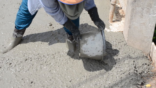Construction worker finishes pouring concrete floor