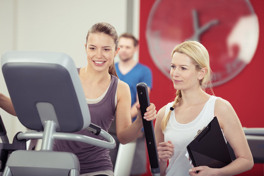 frau trainiert im fitness-studio mit einer trainerin