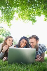 Fototapeta na wymiar Happy students using laptop outside