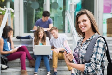 Pretty student smiling at camera outside