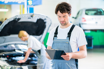 Mechaniker Team arbeitet in Autowerkstatt