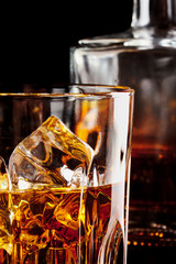 Fragment of a glass of whiskey with ice © alexlukin