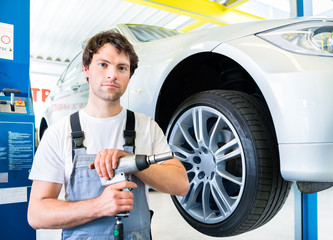 Mechaniker bei Reifenwechsel in Autowerkstatt