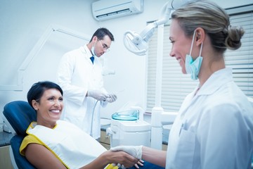 Fototapeta na wymiar Female dentist shaking hands with woman