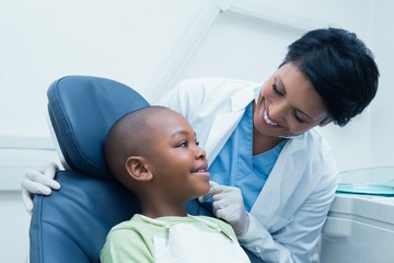 Female dentist examining boys teeth