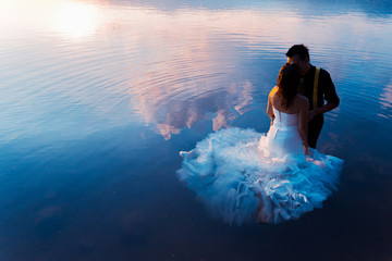 bride and groom on the water in the lake, trash the dress