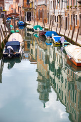 Fototapeta na wymiar Empty gondolas moored in water canal