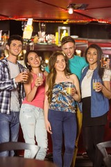 Fototapeta premium Smiling friends drinking beer and mixed drink