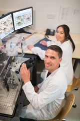 Biochemistry students using large microscope and computer