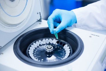 Close up of a chemist using a centrifuge - obrazy, fototapety, plakaty