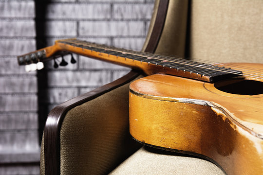 Close-up of acoustic guitar lying on the sofa