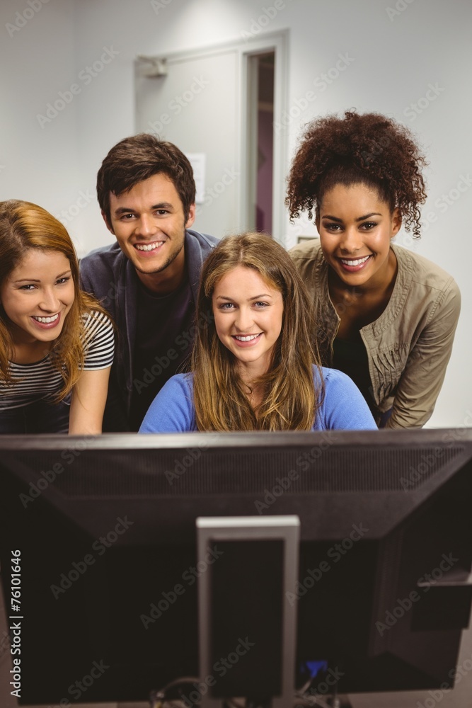 Poster Smiling students using computer together looking at camera