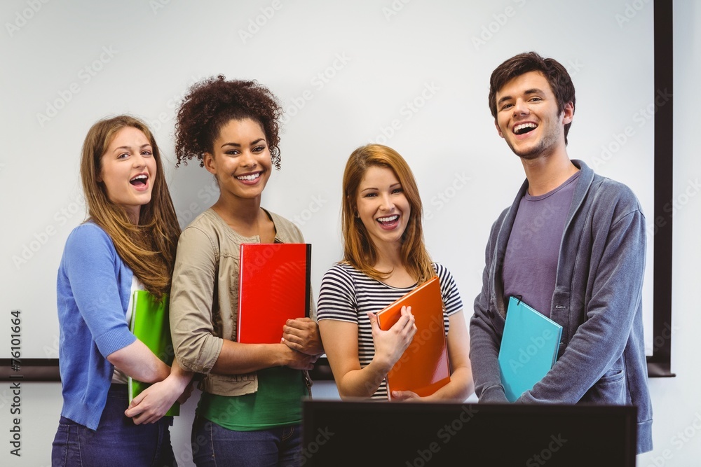 Poster students standing and smiling at camera holding notepads
