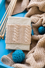 Old notebook with knitted wrap, beige knitted blanket and spokes