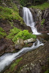 Beautiful waterfall among cliffs in spring time