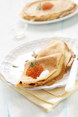 Pancakes with caviar, sour cream and parsley