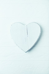 Wooden heart-shaped decoration on a white wooden surface 