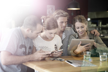 Fototapeta premium Students in campus lounge websurfing on tablet