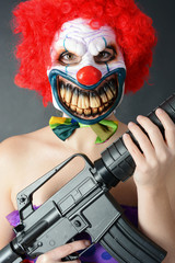 Horror-Clown hält Maschinengewehr