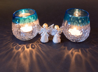 Two little angels and reflections of two tea lights