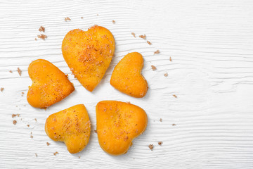 Heart-shaped cookies on wooden background.