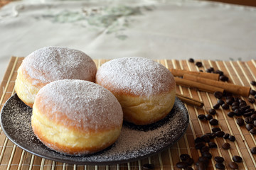 Donuts with powdered sugar on the brown plate