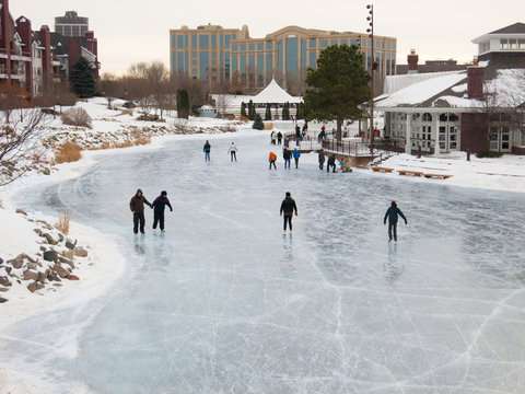 People Skate At Early Evening On A Frozen Lake