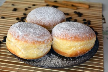 Donuts with powdered sugar on the brown plate