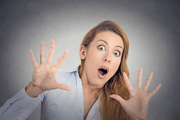 Scared woman trying to dodge isolated grey wall background