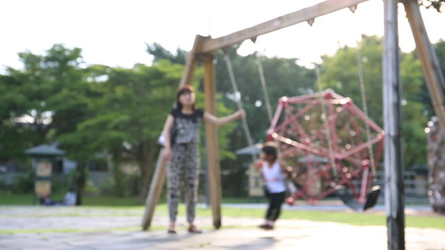 Child rides a swing in Thailand park with your mom .