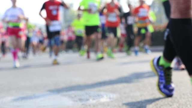 	marathon athletes legs running on city road
