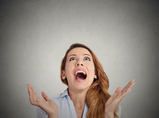 Headshot surprised beautiful woman looking up grey background 