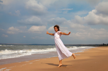 Fototapeta na wymiar woman in a white dress on the ocean coast