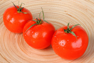 Fresh red tomatoes on wooden plate